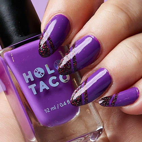 photo of hand with painted nails. the nails are purple with dark red glitter in a striped design at the tip. there is a pronounced lengthwise white streak on each nail caused by the softbox.