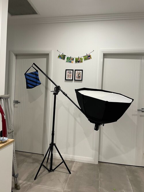 An octagonal softbox attached to a boom on a light stand. the softbox is angled upwards to direct light at the ceiling.